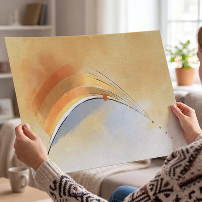A sweeping ochre and orange arc with fine blue accents on a warm cream background single poster print held in hands