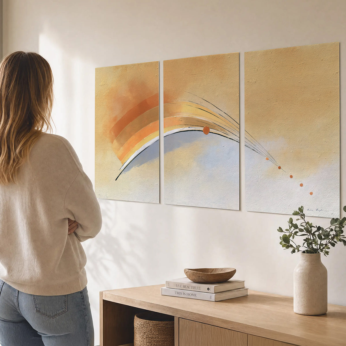 A sweeping ochre and orange arc with fine blue accents on a warm cream background set of 3 poster prints three panel arrangement on a wall