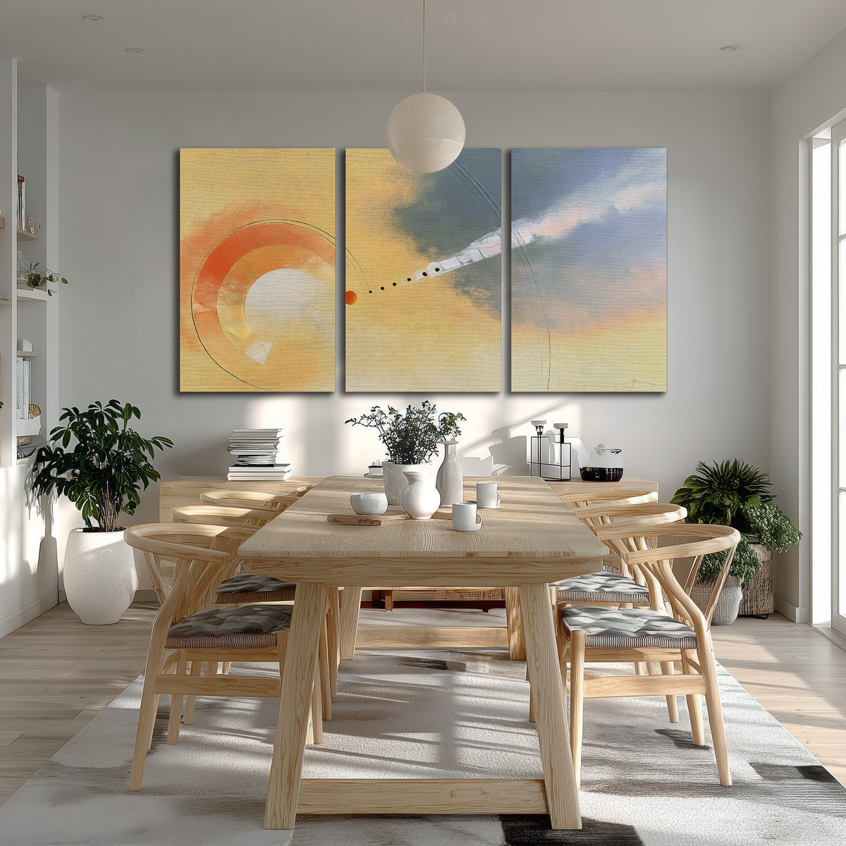 A warm orange circular form and diagonal pale streaks across a muted yellow and blue field 3 piece canvas wall art room and product view