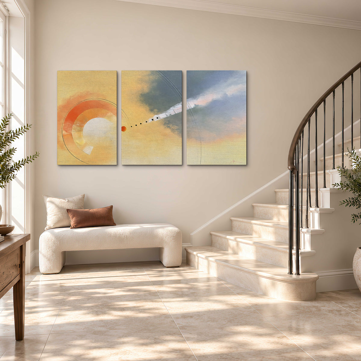 A warm orange circular form and diagonal pale streaks across a muted yellow and blue field 3 piece canvas wall art styled in an interior