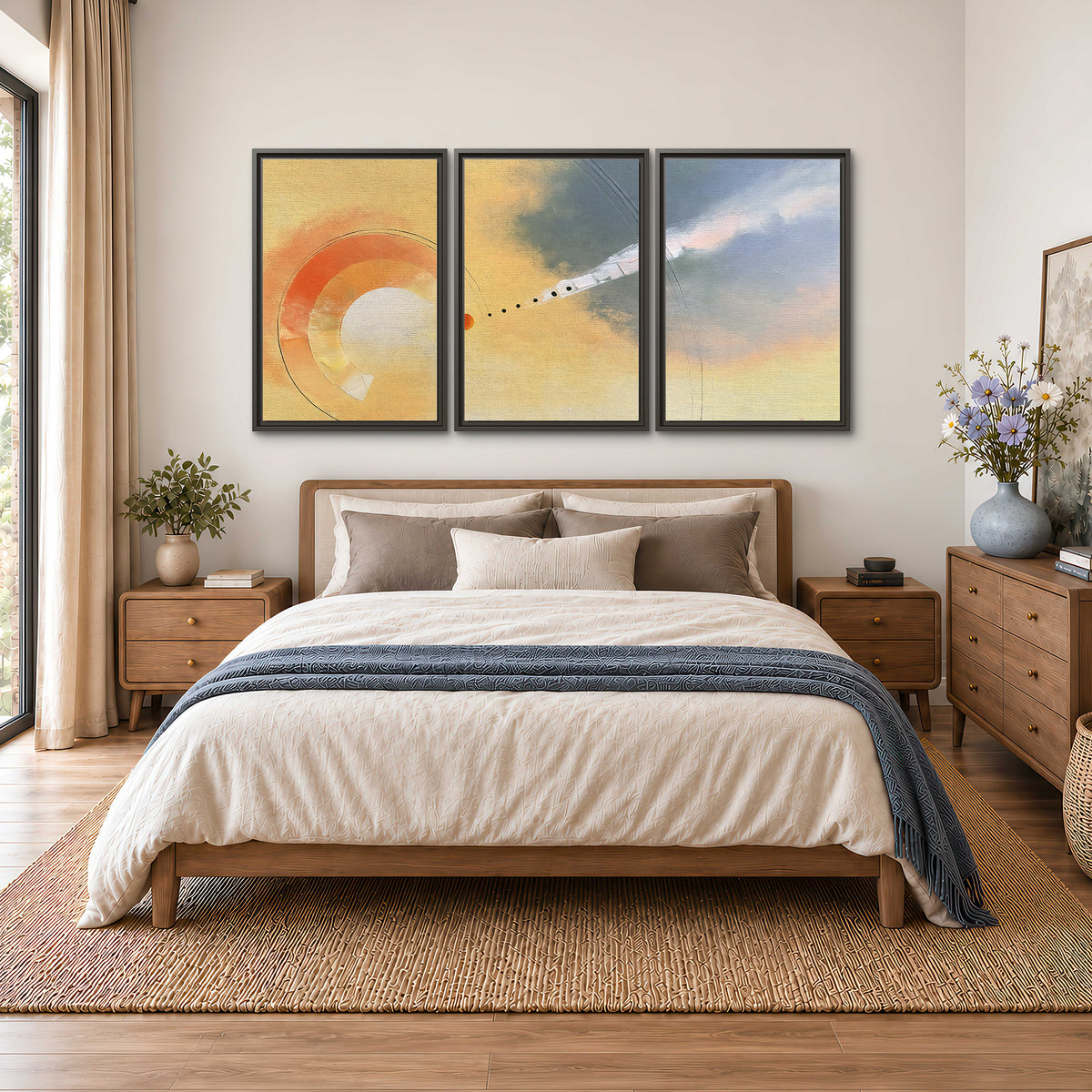 A warm orange circular form and diagonal pale streaks across a muted yellow and blue field 3 piece framed canvas wall art styled in an interior