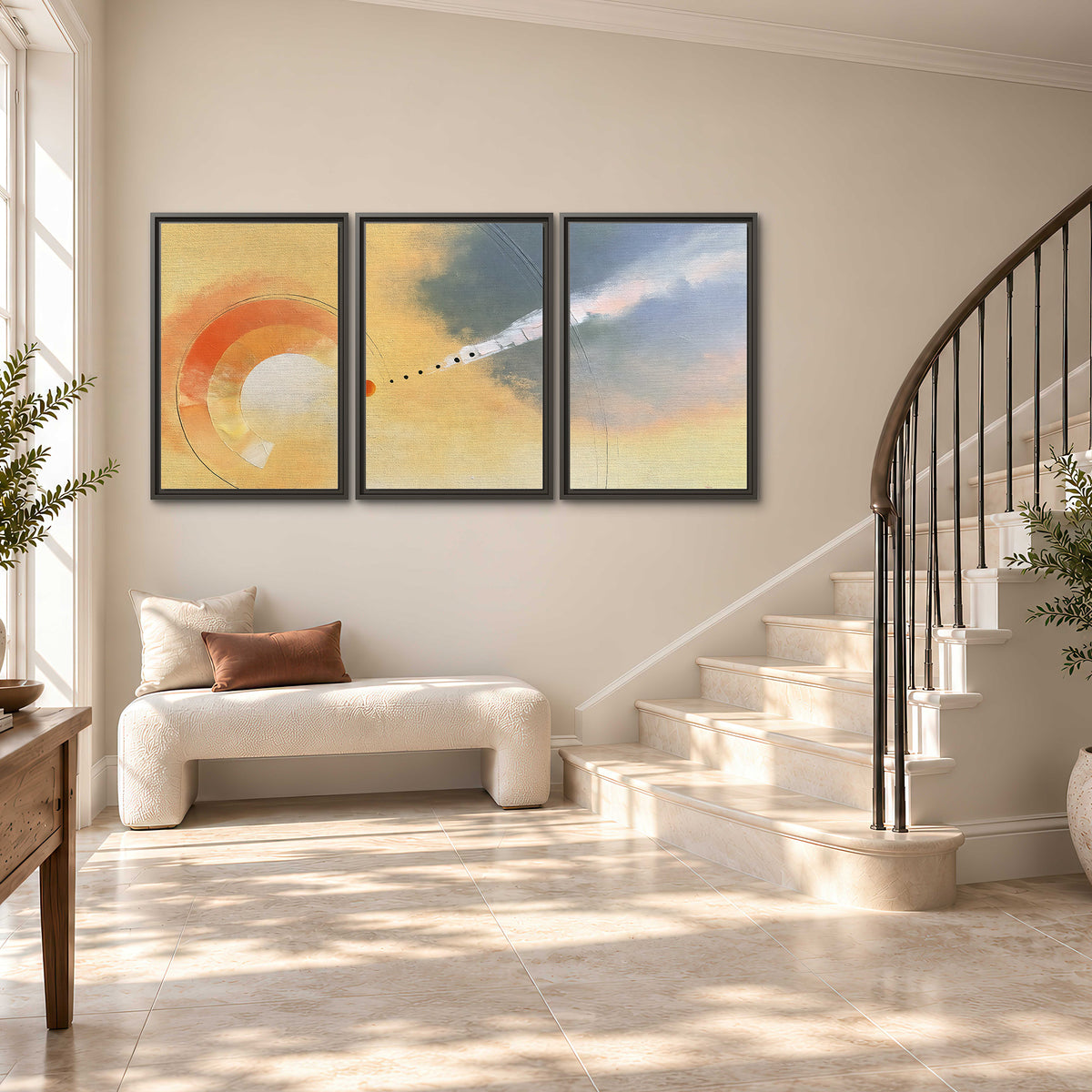 A warm orange circular form and diagonal pale streaks across a muted yellow and blue field 3 piece framed canvas wall art styled in an interior