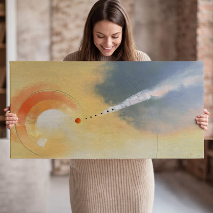 A warm orange circular form and diagonal pale streaks across a muted yellow and blue field single canvas wall art held in hands
