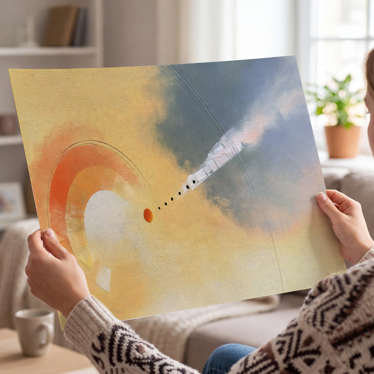 A warm orange circular form and diagonal pale streaks across a muted yellow and blue field single poster print held in hands