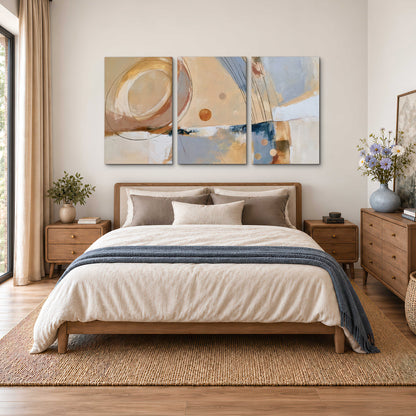 Pale circular forms and fine diagonal lines layered over blue, peach and cream brushstrokes 3 piece canvas wall art styled in an interior