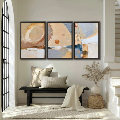 Pale circular forms and fine diagonal lines layered over blue, peach and cream brushstrokes 3 piece framed canvas wall art displayed in a entryway