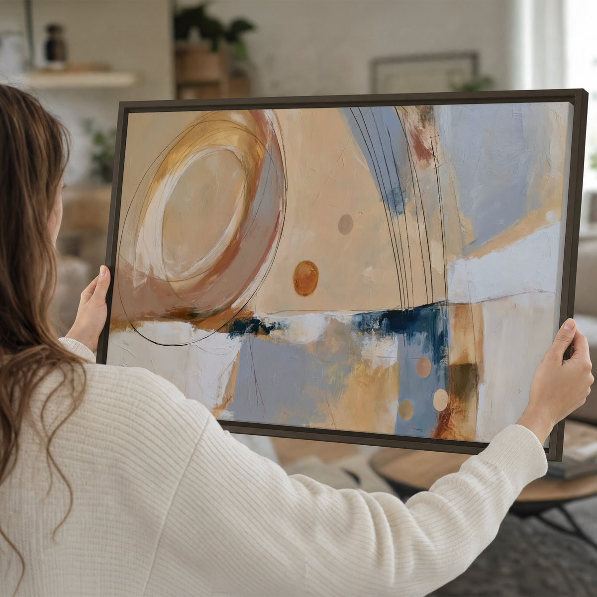 Pale circular forms and fine diagonal lines layered over blue, peach and cream brushstrokes single framed canvas wall art held in hands