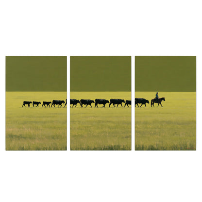 A rider leading a long line of cattle across a wide green and golden plain 3 piece canvas wall art viewed straight on