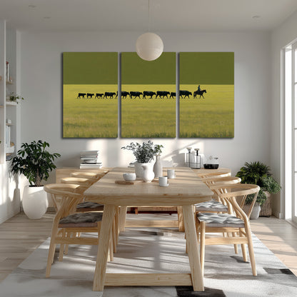 A rider leading a long line of cattle across a wide green and golden plain 3 piece canvas wall art room and product view