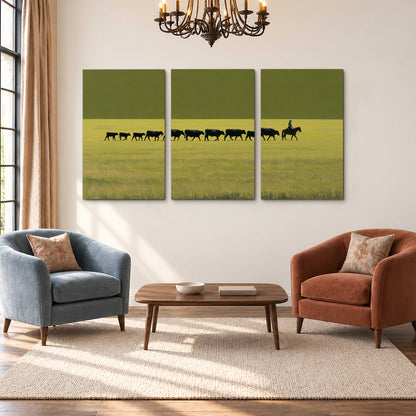 A rider leading a long line of cattle across a wide green and golden plain 3 piece canvas wall art styled in an interior