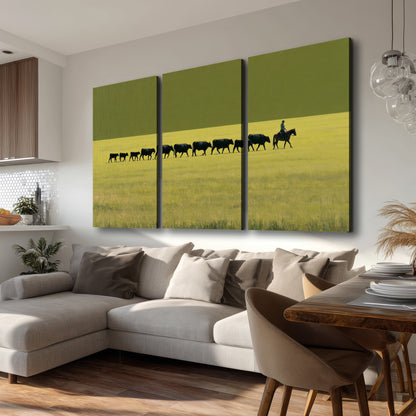 A rider leading a long line of cattle across a wide green and golden plain 3 piece canvas wall art room and product view