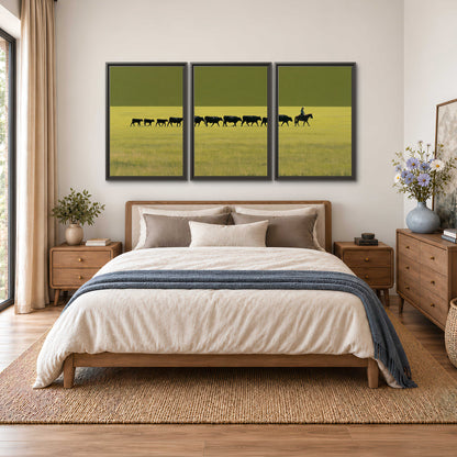 A rider leading a long line of cattle across a wide green and golden plain 3 piece framed canvas wall art styled in an interior