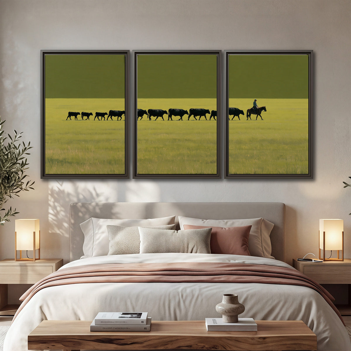 A rider leading a long line of cattle across a wide green and golden plain 3 piece framed canvas wall art displayed in a bedroom