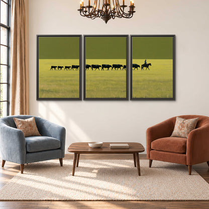 A rider leading a long line of cattle across a wide green and golden plain 3 piece framed canvas wall art styled in an interior