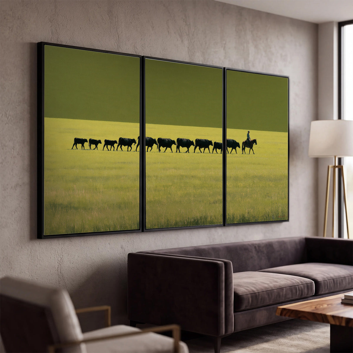 A rider leading a long line of cattle across a wide green and golden plain 3 piece framed canvas wall art displayed in a modern living room