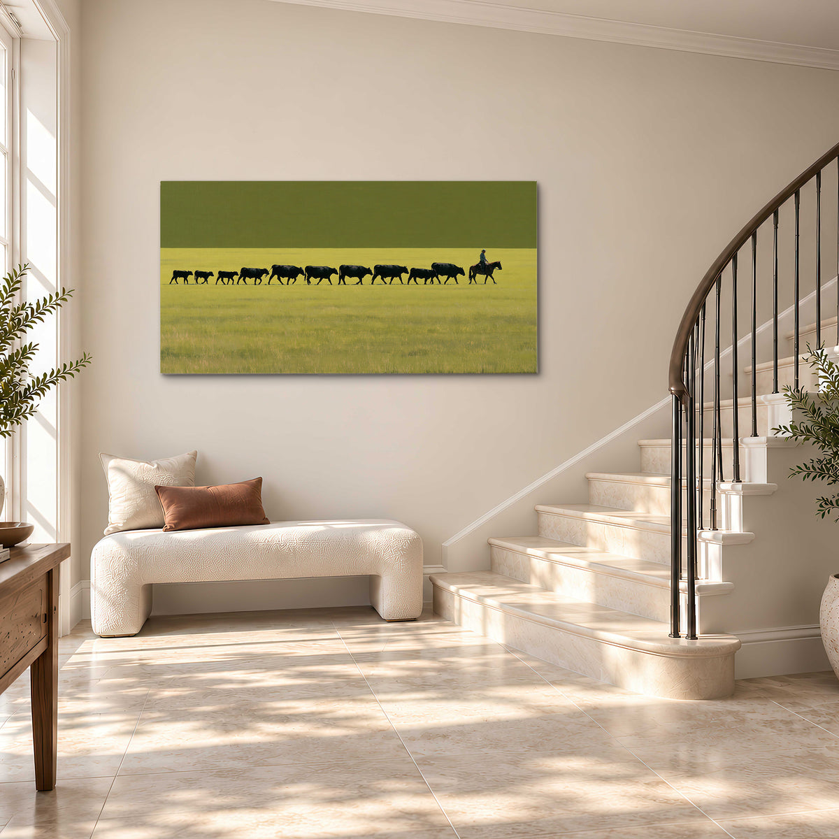A rider leading a long line of cattle across a wide green and golden plain single canvas wall art styled in an interior