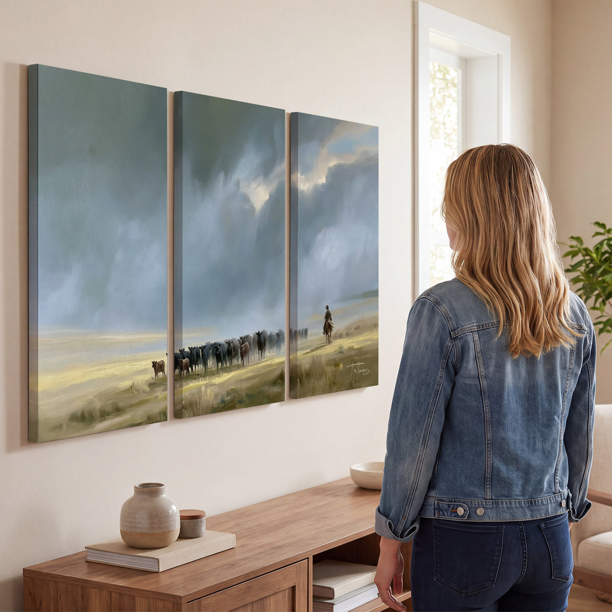A rider and cattle moving across a sunlit grassland beneath a dramatic blue-gray sky 3 piece canvas wall art three panel arrangement on a wall
