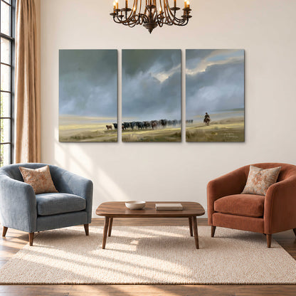 A rider and cattle moving across a sunlit grassland beneath a dramatic blue-gray sky 3 piece canvas wall art styled in an interior