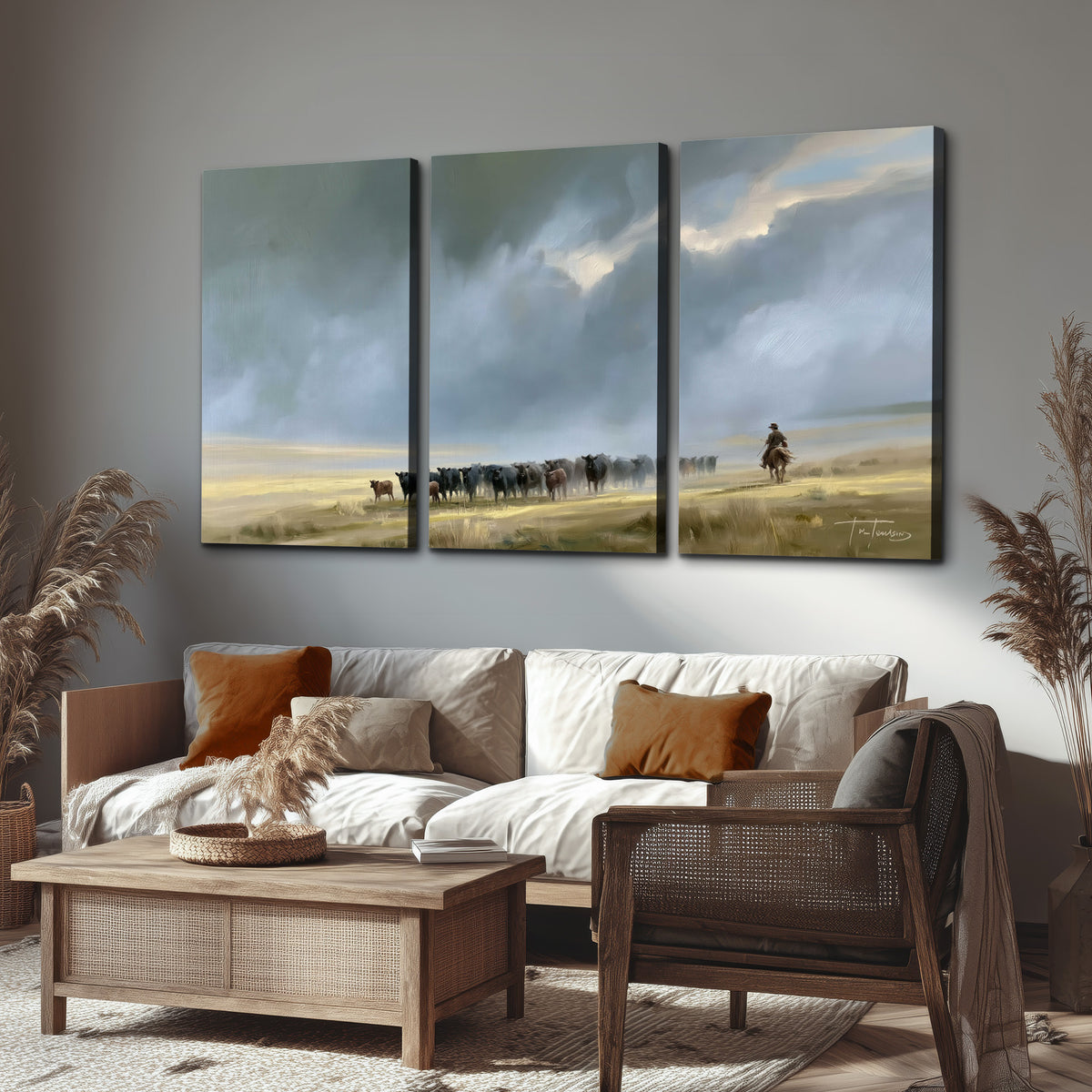 A rider and cattle moving across a sunlit grassland beneath a dramatic blue-gray sky 3 piece canvas wall art displayed in a rustic living room