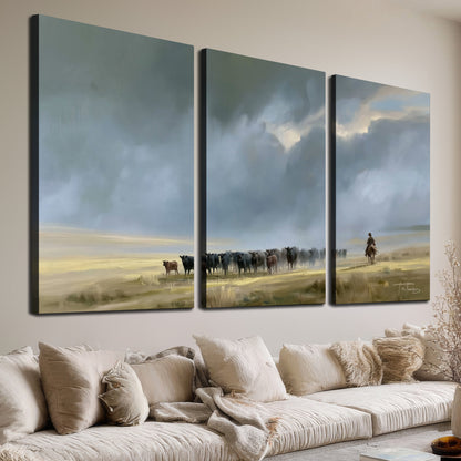 A rider and cattle moving across a sunlit grassland beneath a dramatic blue-gray sky 3 piece canvas wall art room and product view