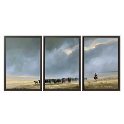 A rider and cattle moving across a sunlit grassland beneath a dramatic blue-gray sky 3 piece framed canvas wall art viewed straight on
