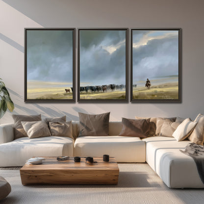 A rider and cattle moving across a sunlit grassland beneath a dramatic blue-gray sky 3 piece framed canvas wall art displayed in a living room