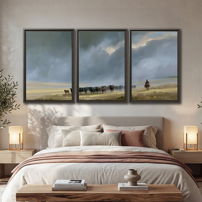 A rider and cattle moving across a sunlit grassland beneath a dramatic blue-gray sky 3 piece framed canvas wall art displayed in a bedroom