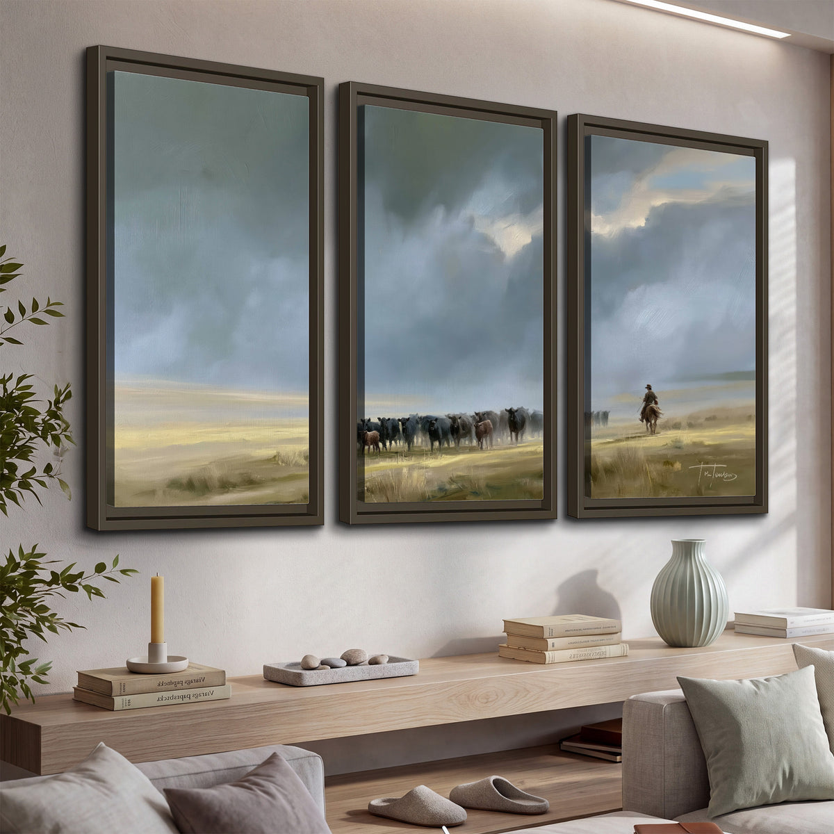 A rider and cattle moving across a sunlit grassland beneath a dramatic blue-gray sky 3 piece framed canvas wall art displayed in a console