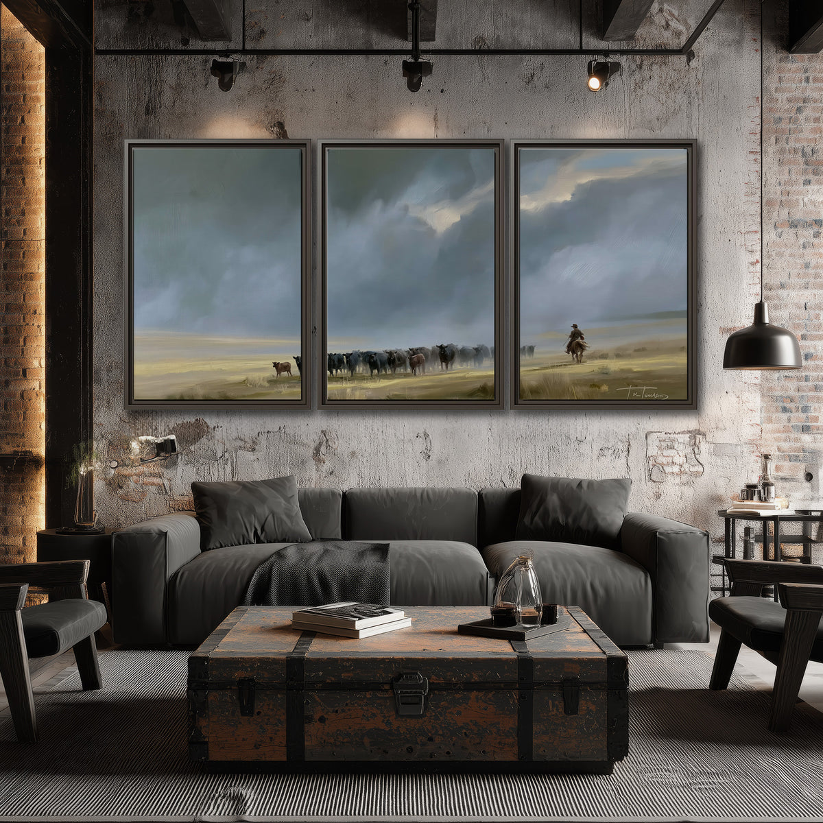 A rider and cattle moving across a sunlit grassland beneath a dramatic blue-gray sky 3 piece framed canvas wall art displayed in a industrial room