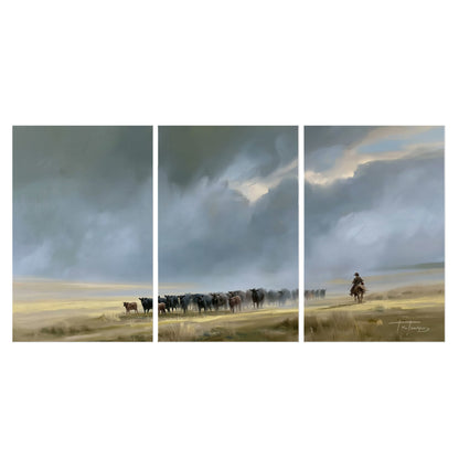 A rider and cattle moving across a sunlit grassland beneath a dramatic blue-gray sky set of 3 poster prints viewed straight on