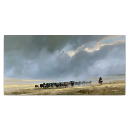 A rider and cattle moving across a sunlit grassland beneath a dramatic blue-gray sky single canvas wall art viewed straight on